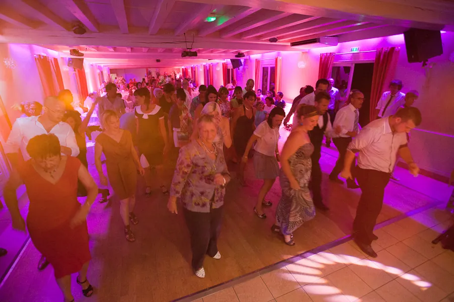 Piste de danse pleine, invités de tous âges dansant pendant une soirée animée par un orchestre live